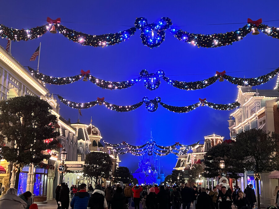 Main Street y el Castillo de Disneyland Paris de noche decorado de Navidad
