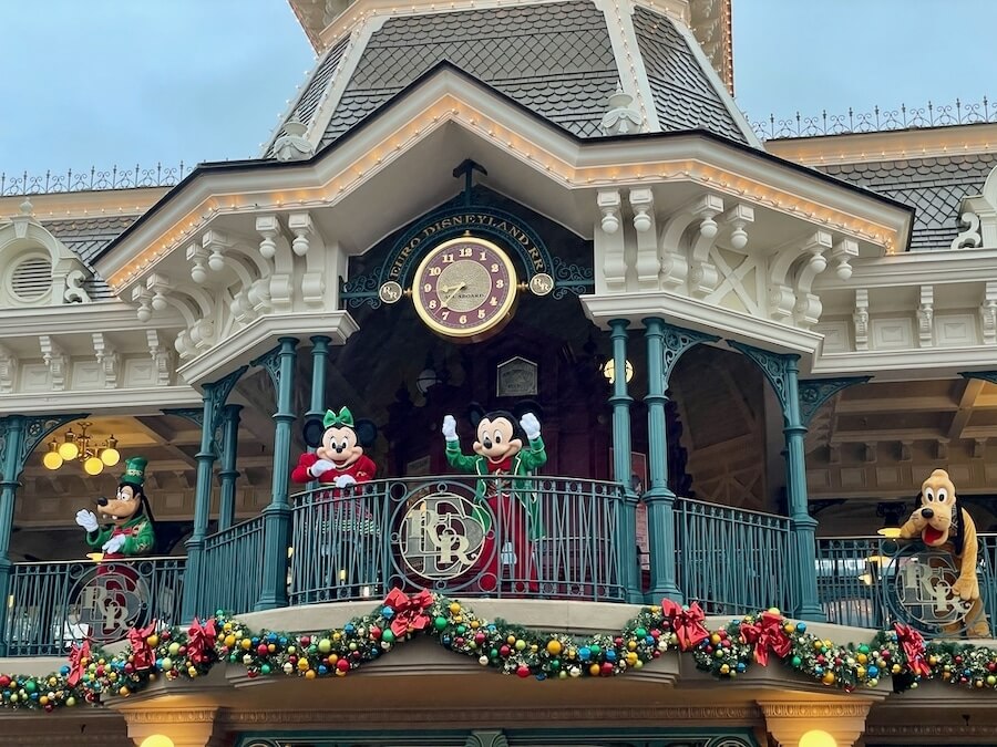 Mickey y sus amigos saludando en la entrada de Disneyland Paris en Navidad
