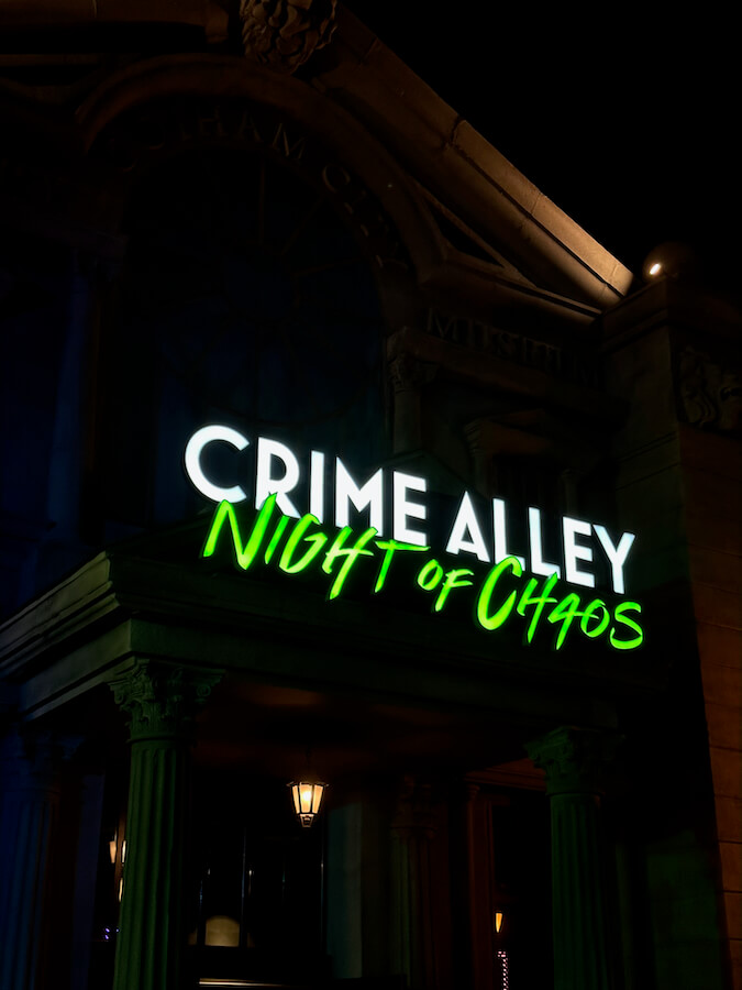 Cartel iluminado de Crime Alley Night of Chaos - Nuevo pasaje del terror 2023 en Halloween de Parque Warner